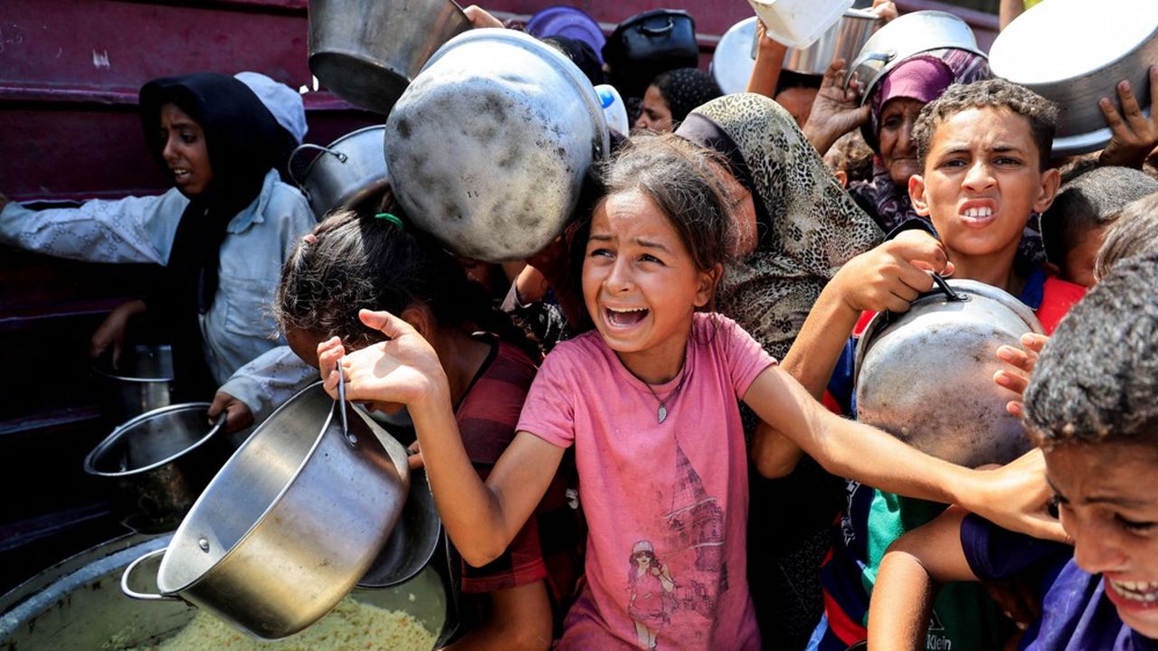 Palestinians wait to receive food from a charity kitchen, in Khan Younis, southern Gaza Strip, August 21, 2025. REUTERS/Hatem Khaled     TPX IMAGES OF THE DAY